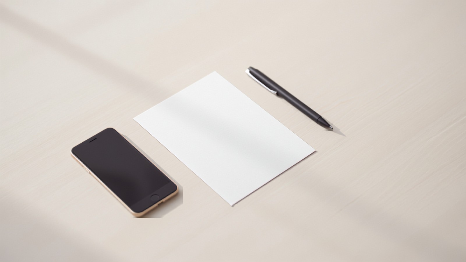A single printed invoice lying on a plain wooden desk beside a phone and a pen in afternoon light, illustrating the document an Indian creator sends a brand after delivering a collaboration